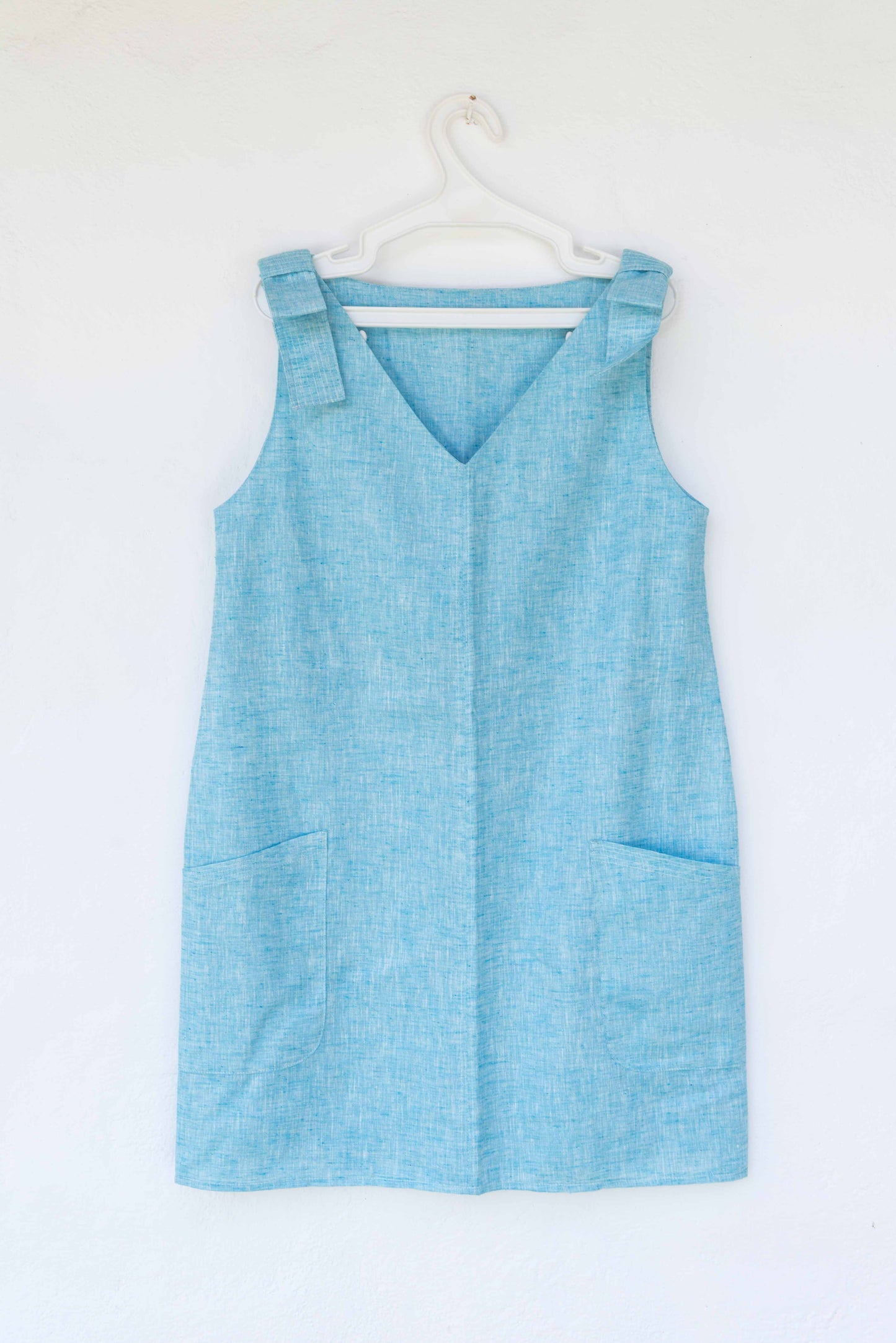 VESTIDO CAMISERO CORTO DE LINO LIVIANO CELESTE, CON BOLSILLOS.